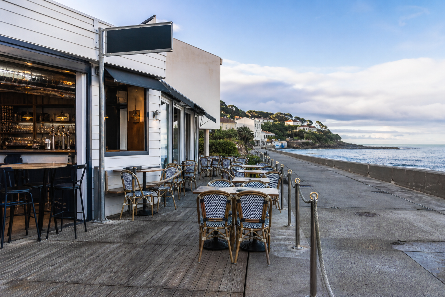 Vue large d’un bar en bord de mer à Saint-Paul avec terrasse littorale et espace maritime réglementé en arrière-plan.